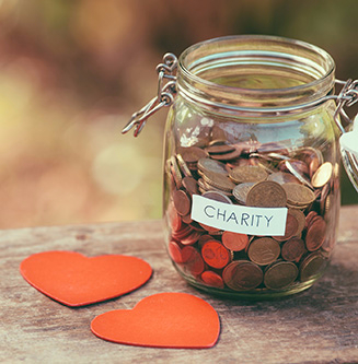 pennies in a jar marked charity representing managing your charitable giving